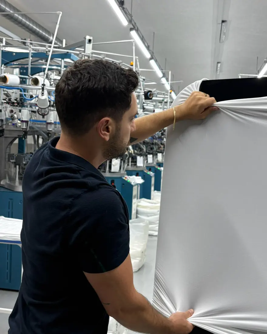 Overfit Seamless technician stretching finished seamless knit fabric to check its recovery
